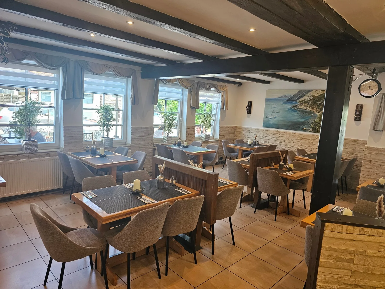 Gastraum von Restaurant Kreta in Grömitz mit Holzbalken und Küstengemälde